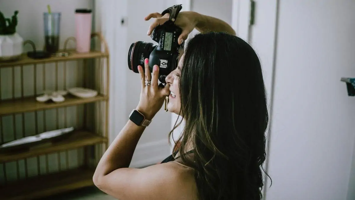 A Woman Holding a Black Dslr Camera
