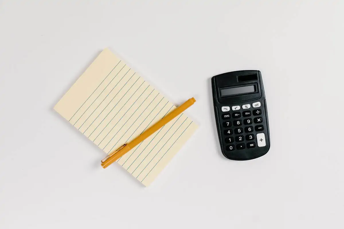 Black Calculator Beside Brown Pencil on White Ruled Paper