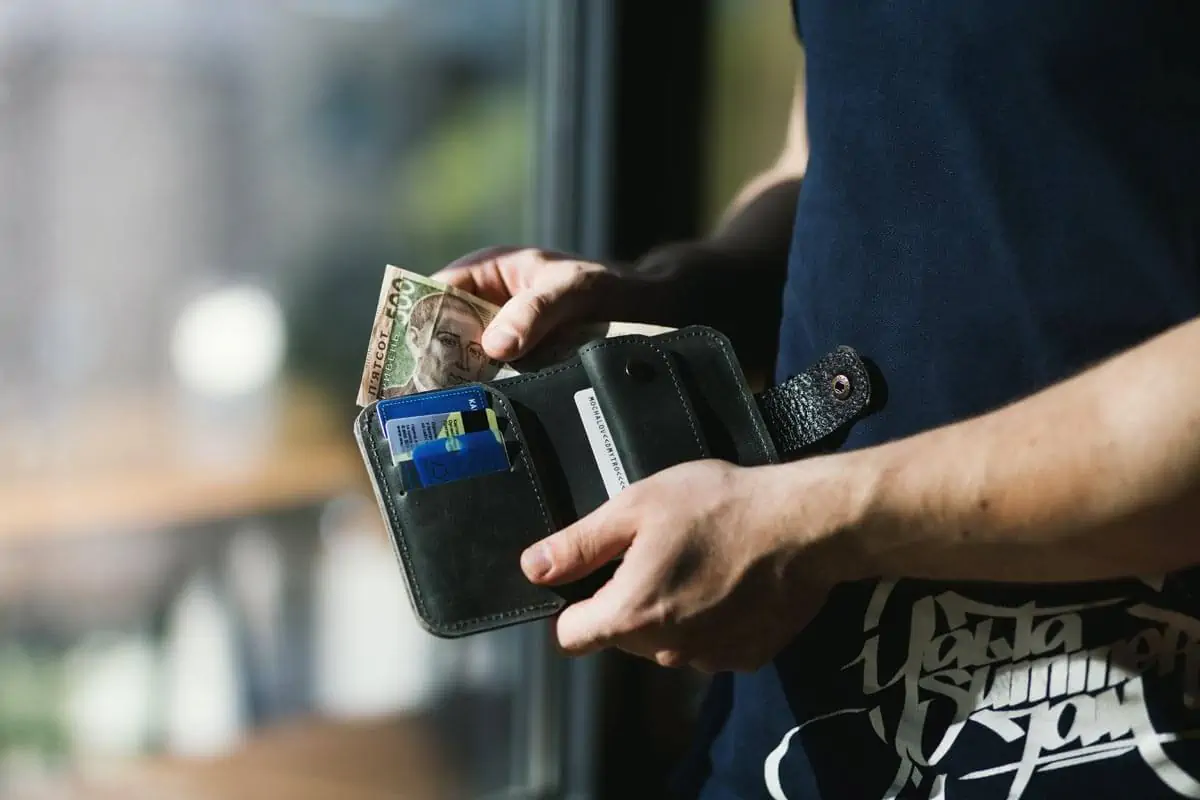 Person Holding Black Leather Wallet with Money
