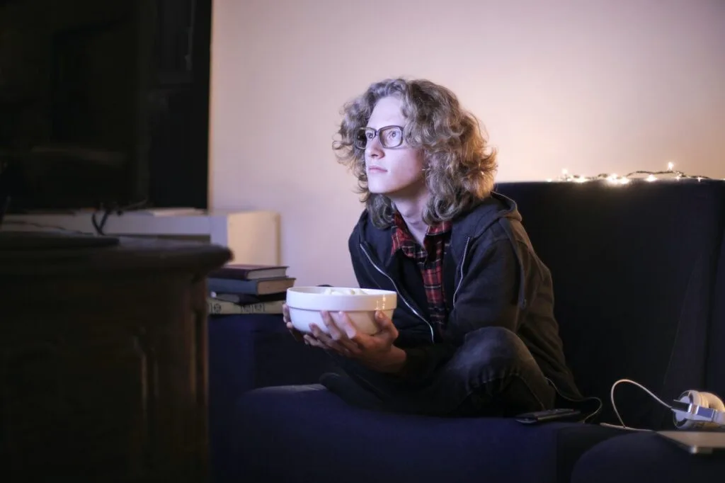 focused man with bowl of popcorn watching tv