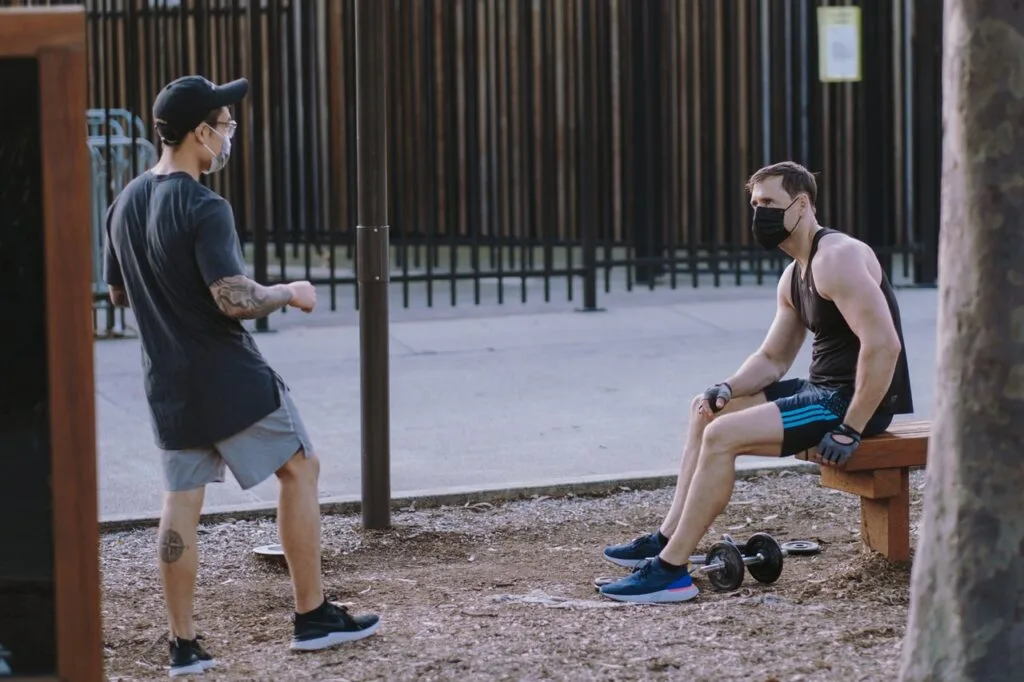 two men talking and doing workout