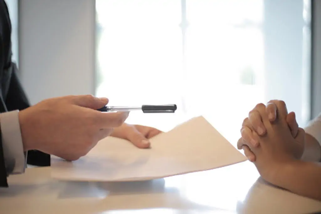 person handing over document to sign