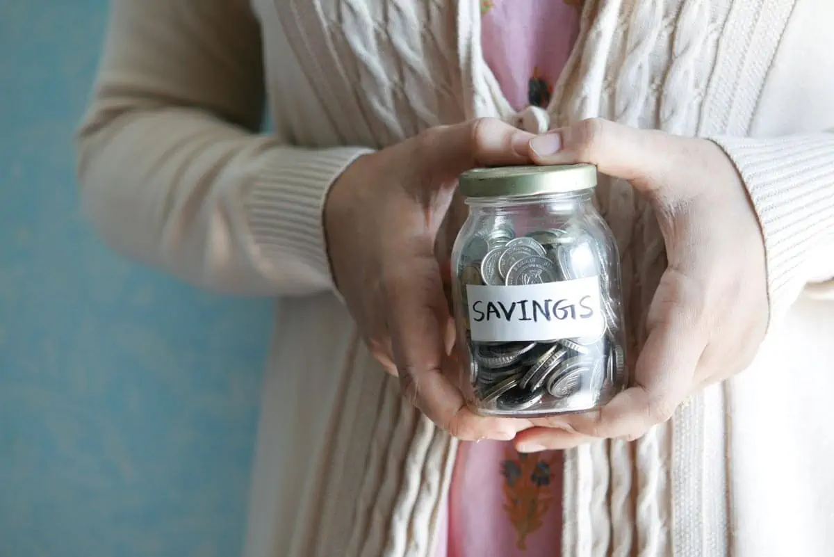 Photo of a Person's Hands holding jar of coins