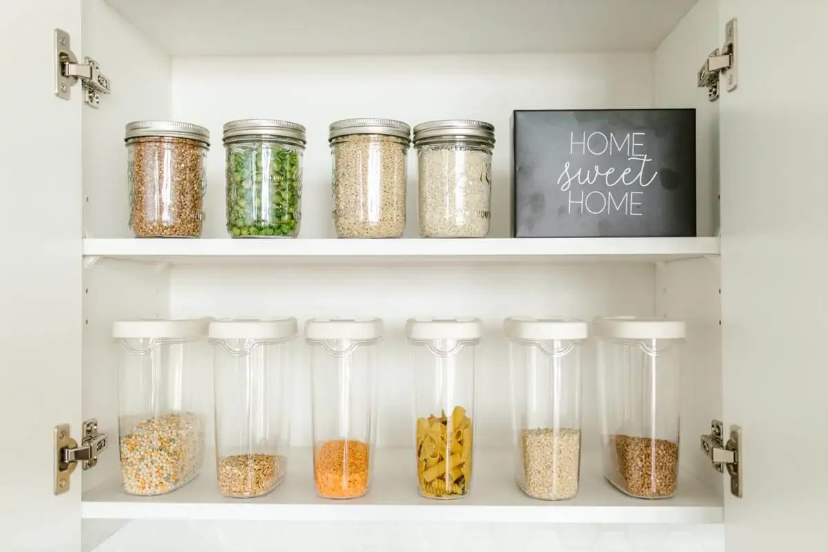 clear glass jars on white wooden shelf