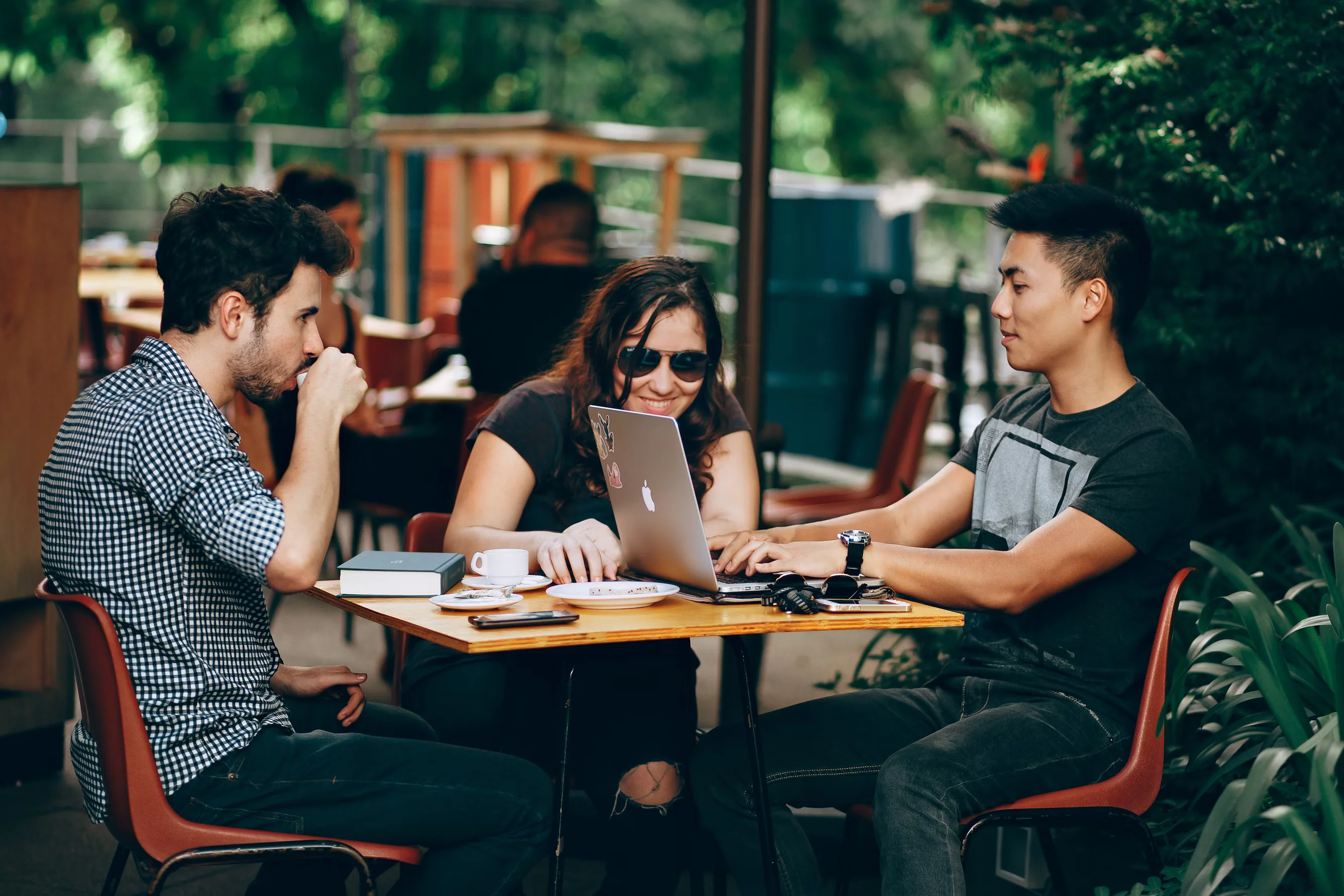 three person sitting and talking