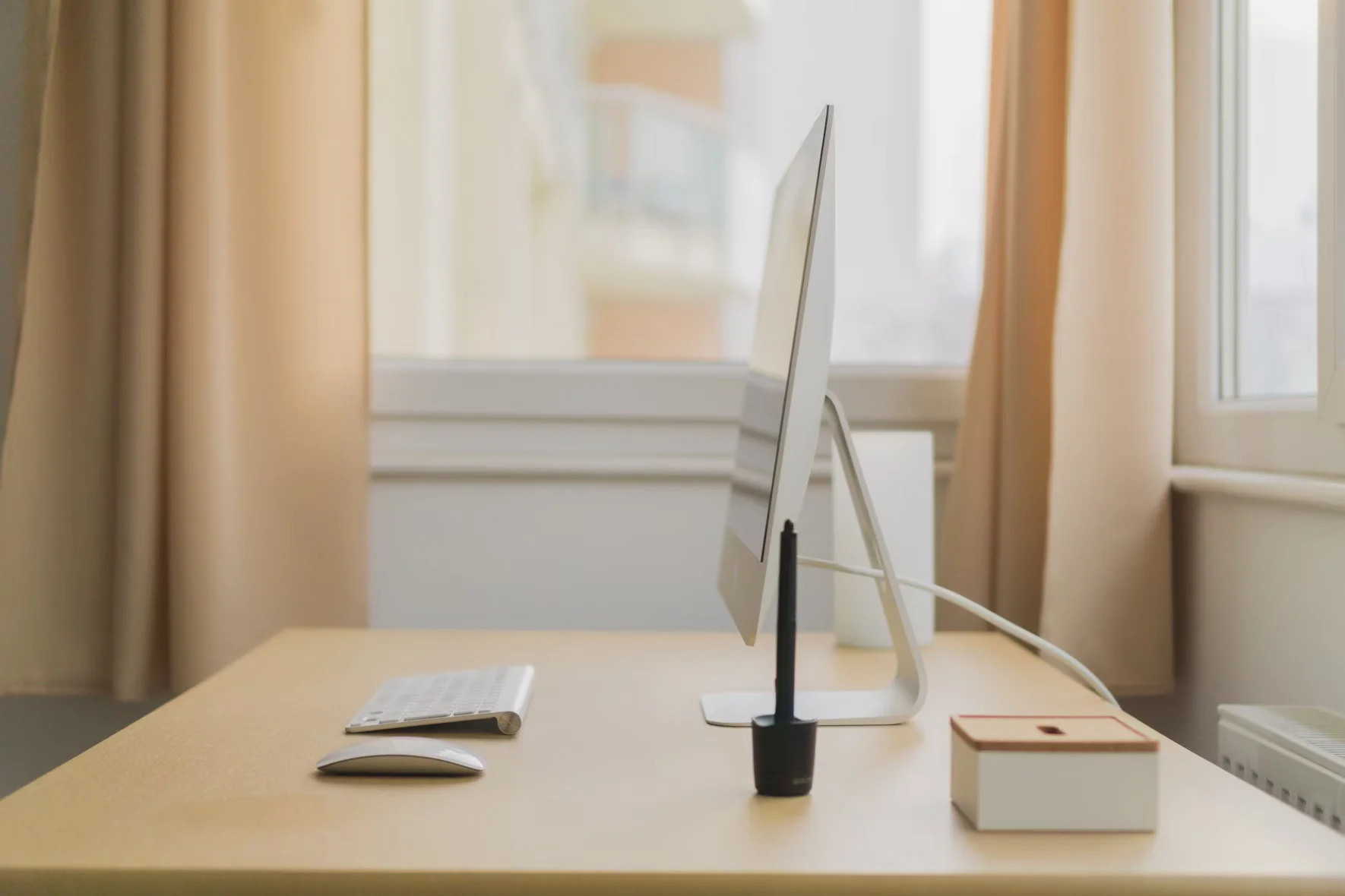 apple imac on wooden desk near window