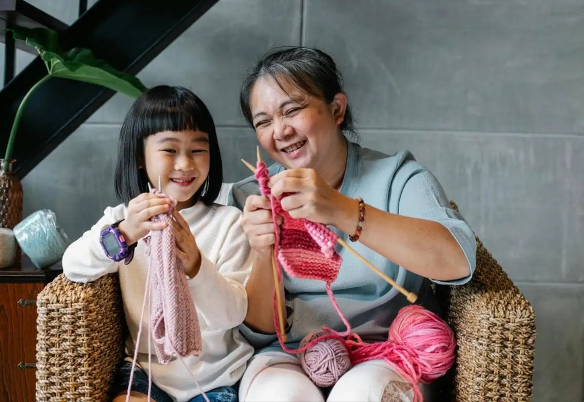 positive elderly ethnic woman with adorable granddaughter