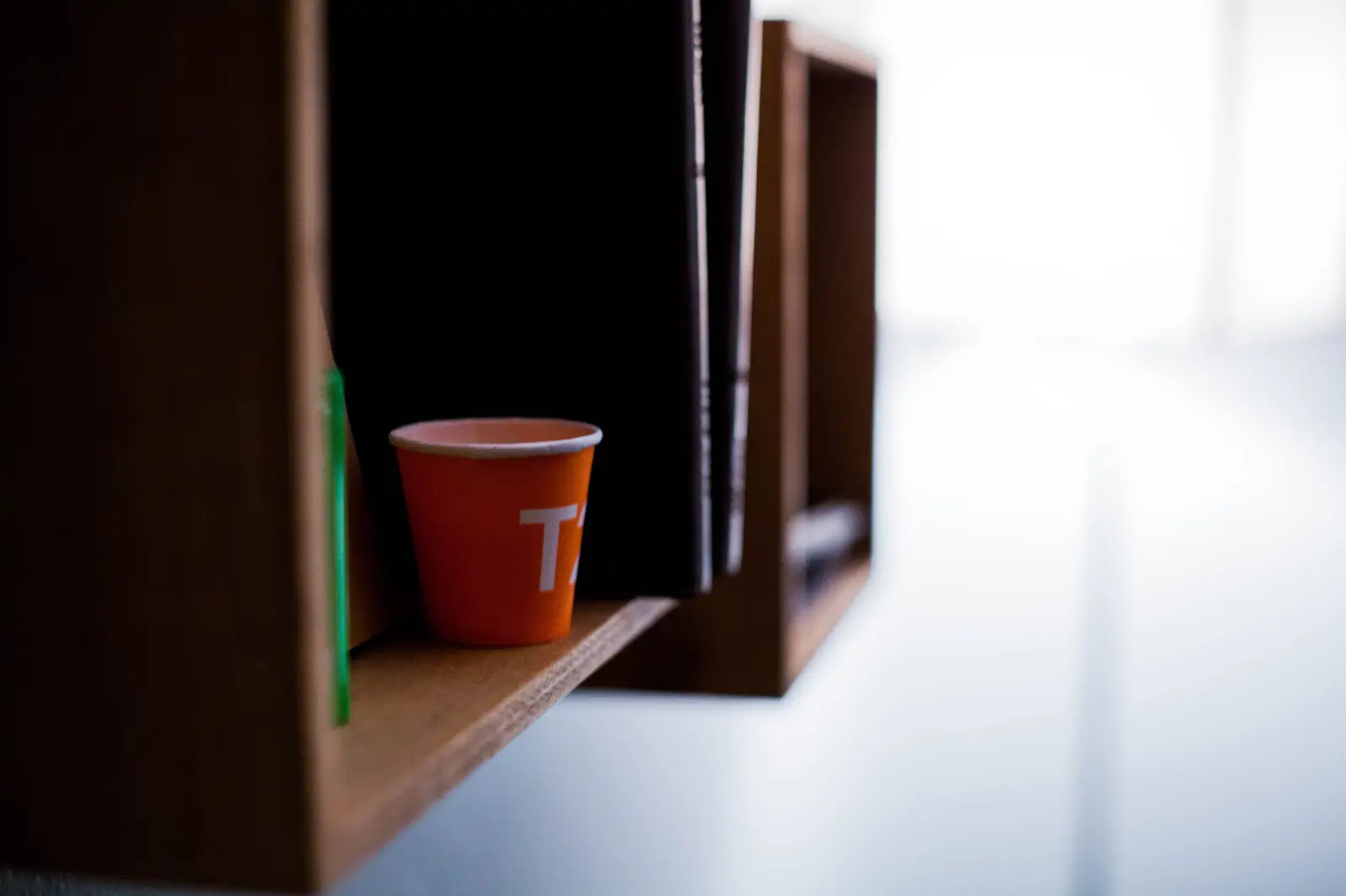 red-disposable-cup-on-brown-wooden-shelf