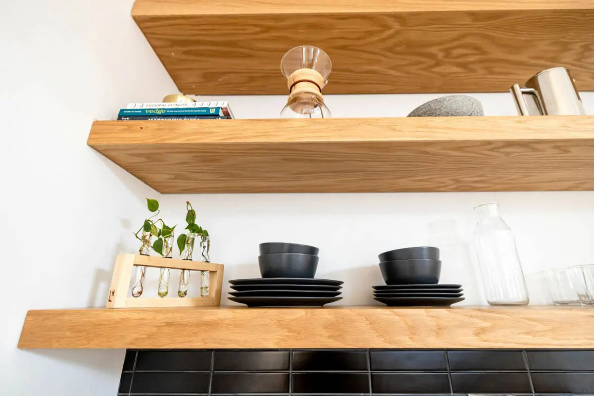 white and black ceramic mugs on brown wooden wall rack