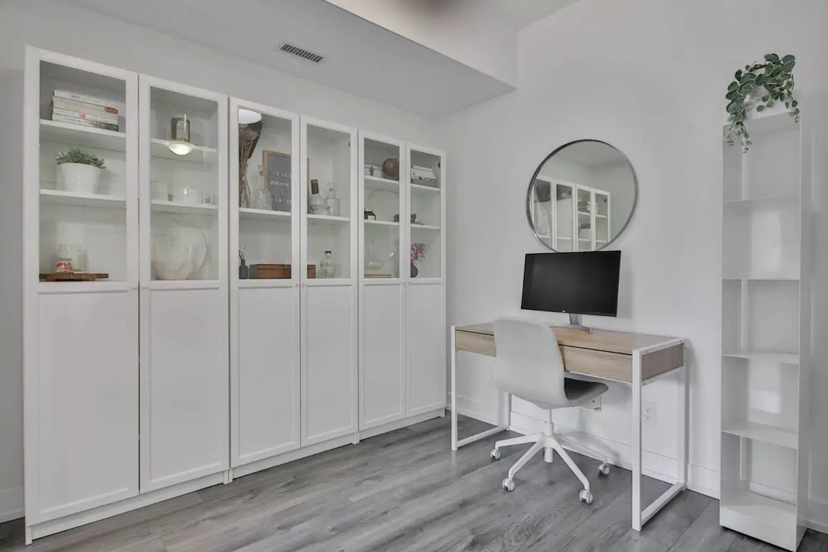 a-white-room-with-a-desk-and-a-mirror