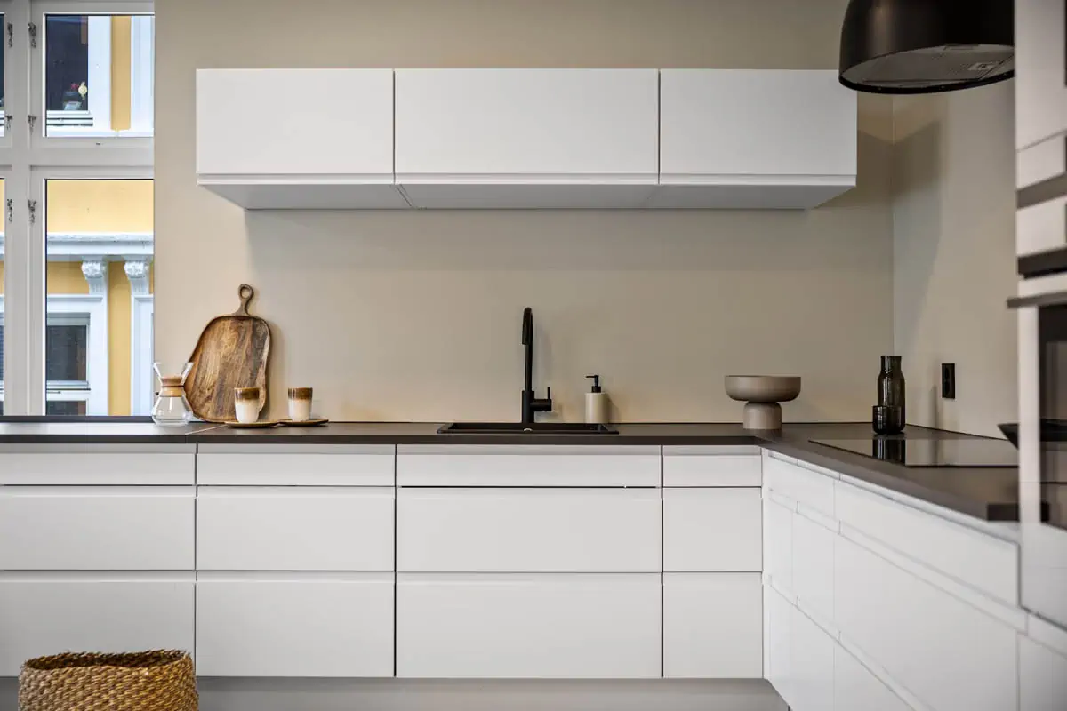 a-kitchen-with-white-cabinets-and-a-window