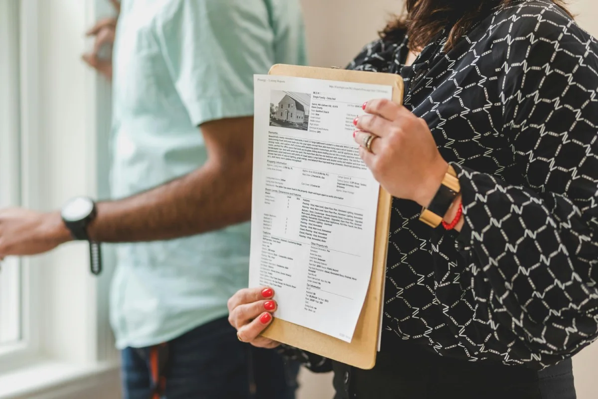 a-person-holding-a-paper-with-a-picture-of-a-house