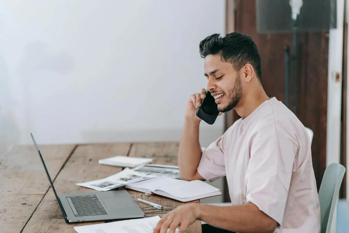 happy-businessman-speaking-on-phone-at-workplace