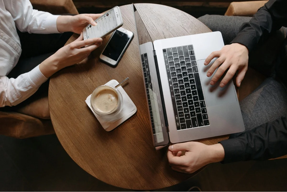 two-people-using-laptop-and-smartphone