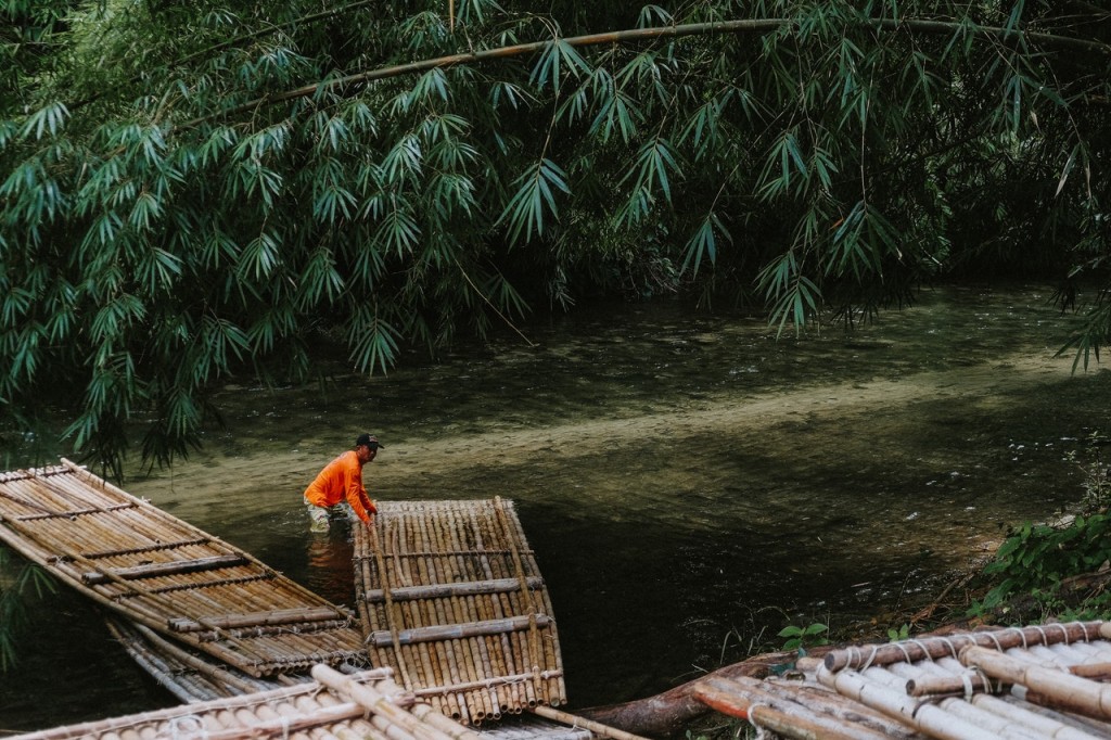 man in the river a pulling bamboo raft to the water