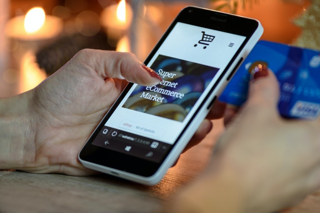 person using black and white smartphone andholding blue