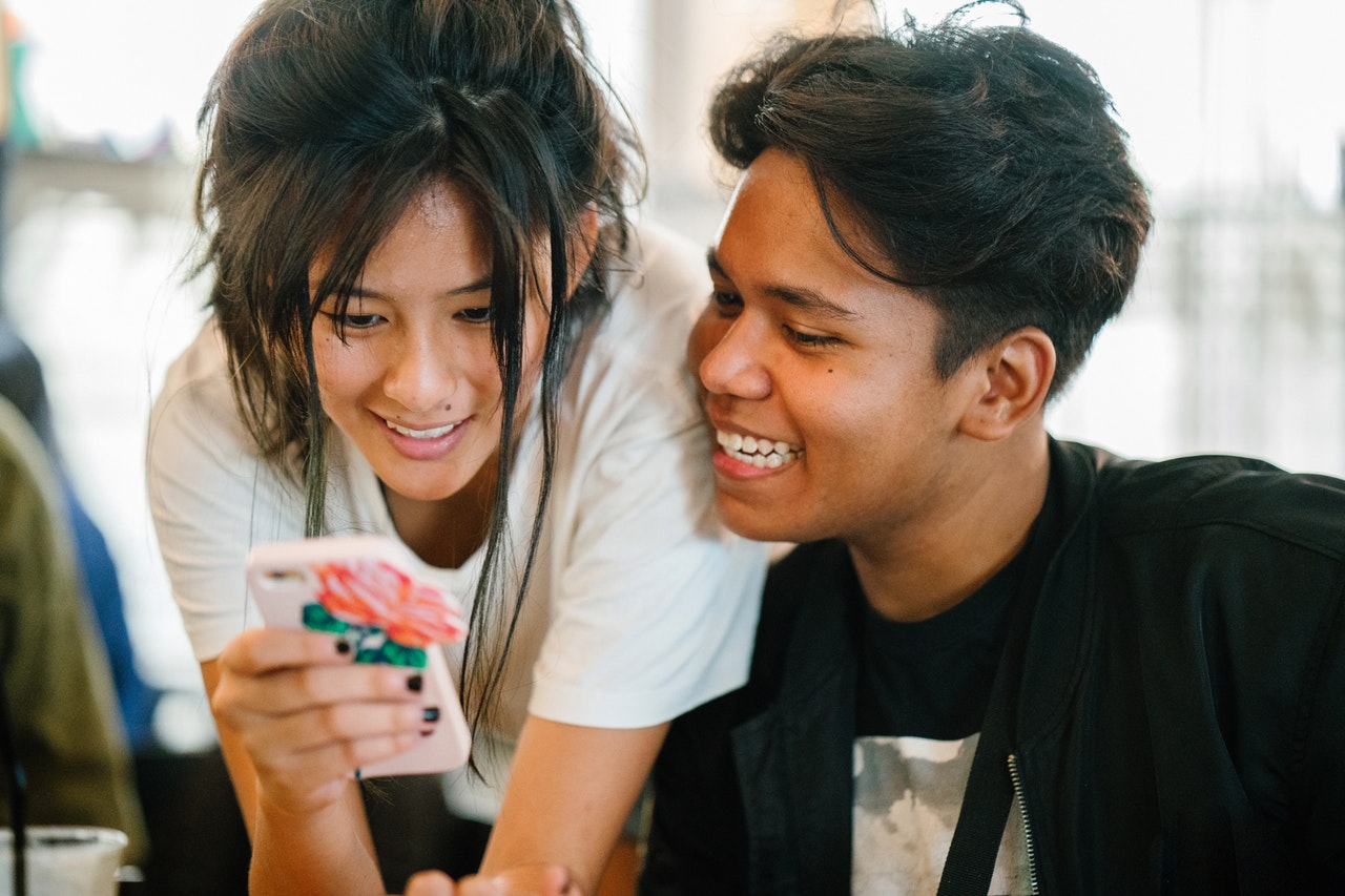 two millennials smiling mobile phone